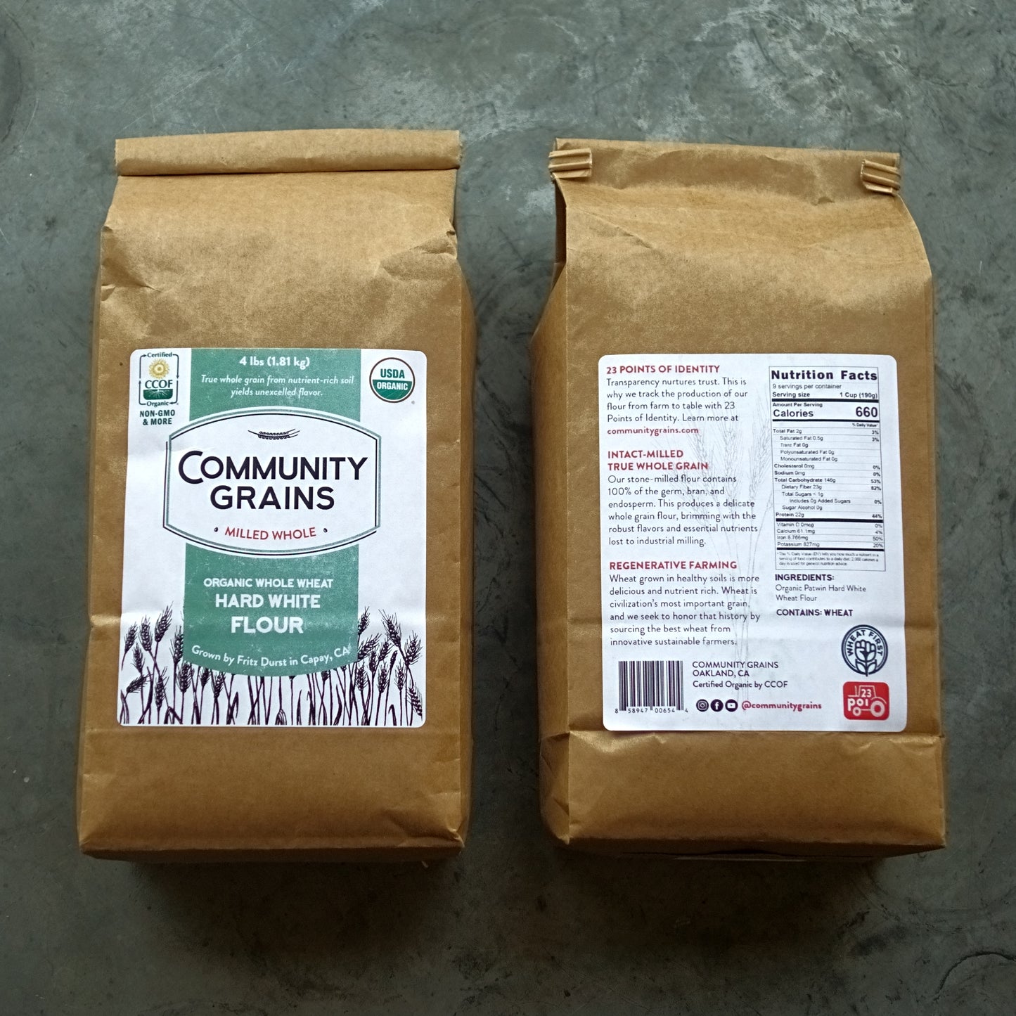 Two brown bags of Community Grains flour on a gray surface